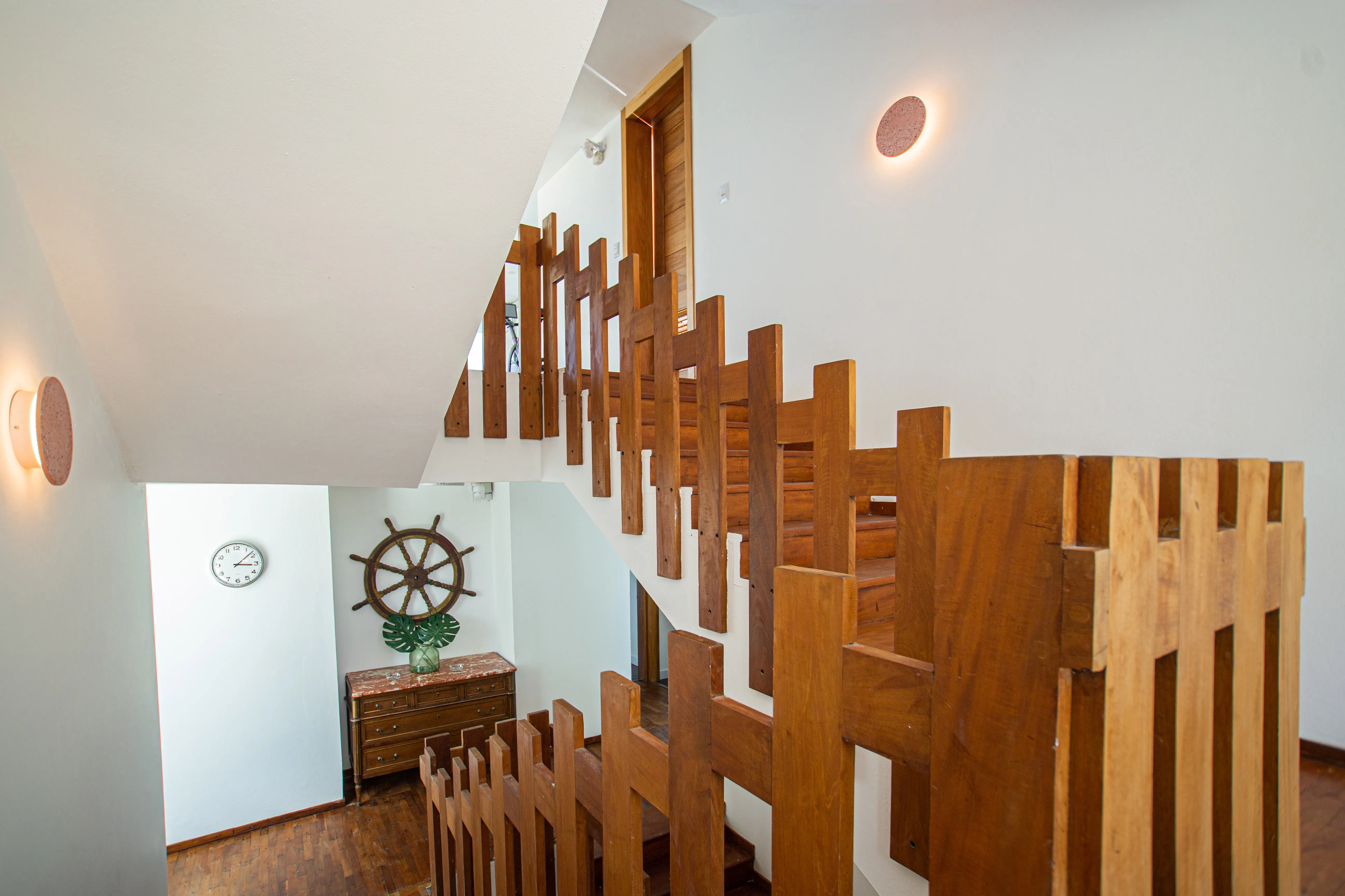 Sculptural wood-slat staircase at the heart of the villa