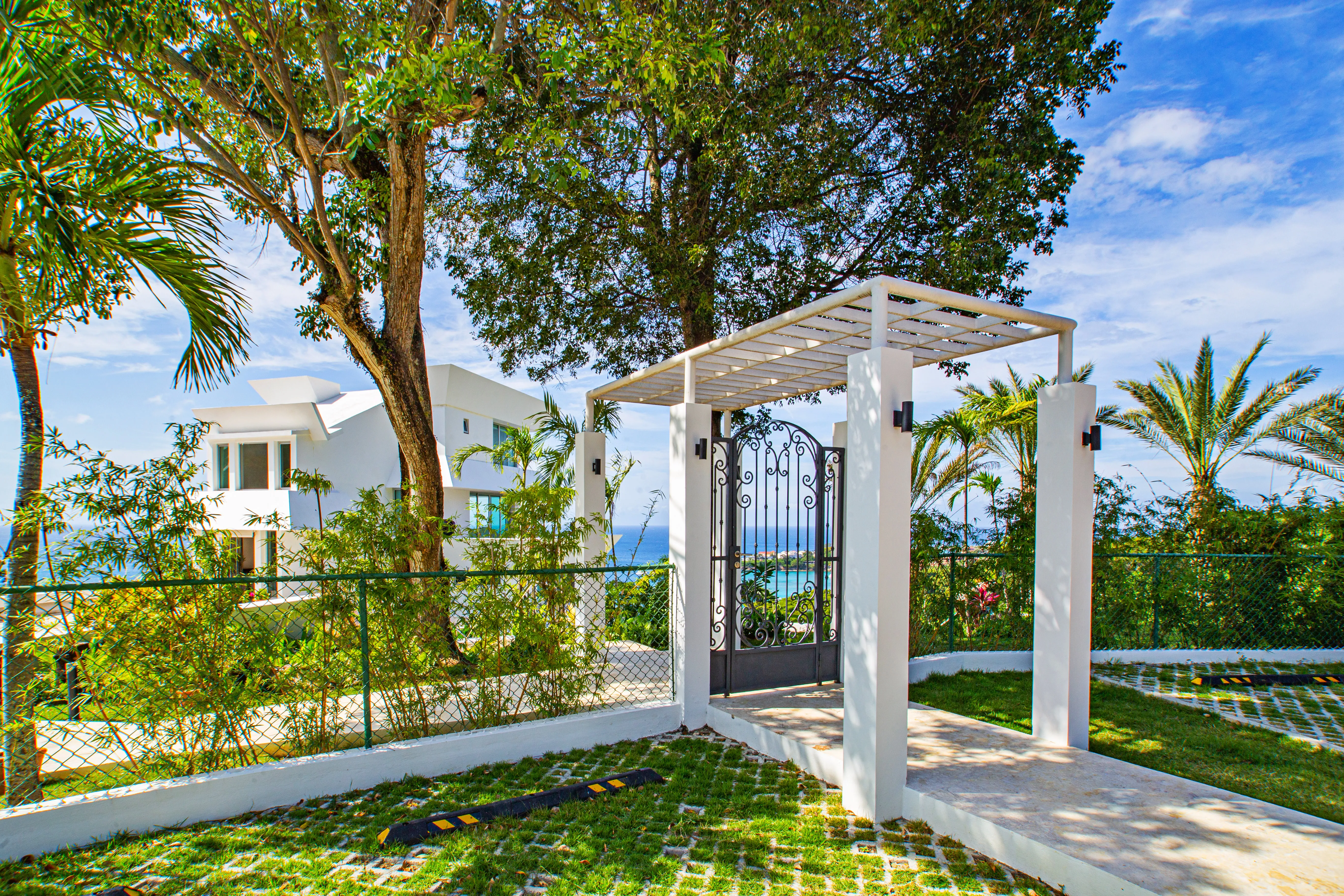 Wrought-iron garden gate and pergola, the ocean beyond