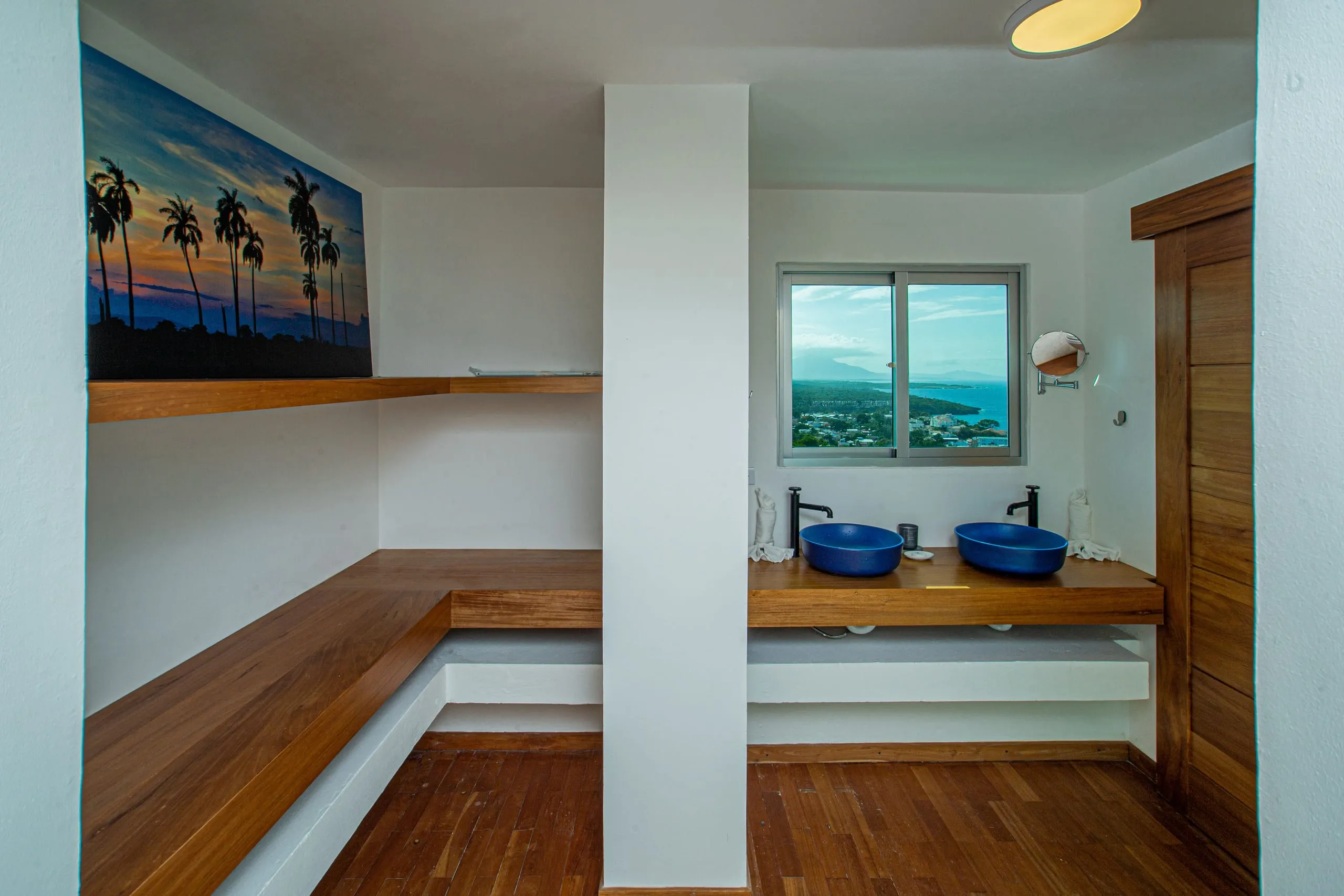 Ensuite bathroom with twin vessel sinks and an ocean-view window