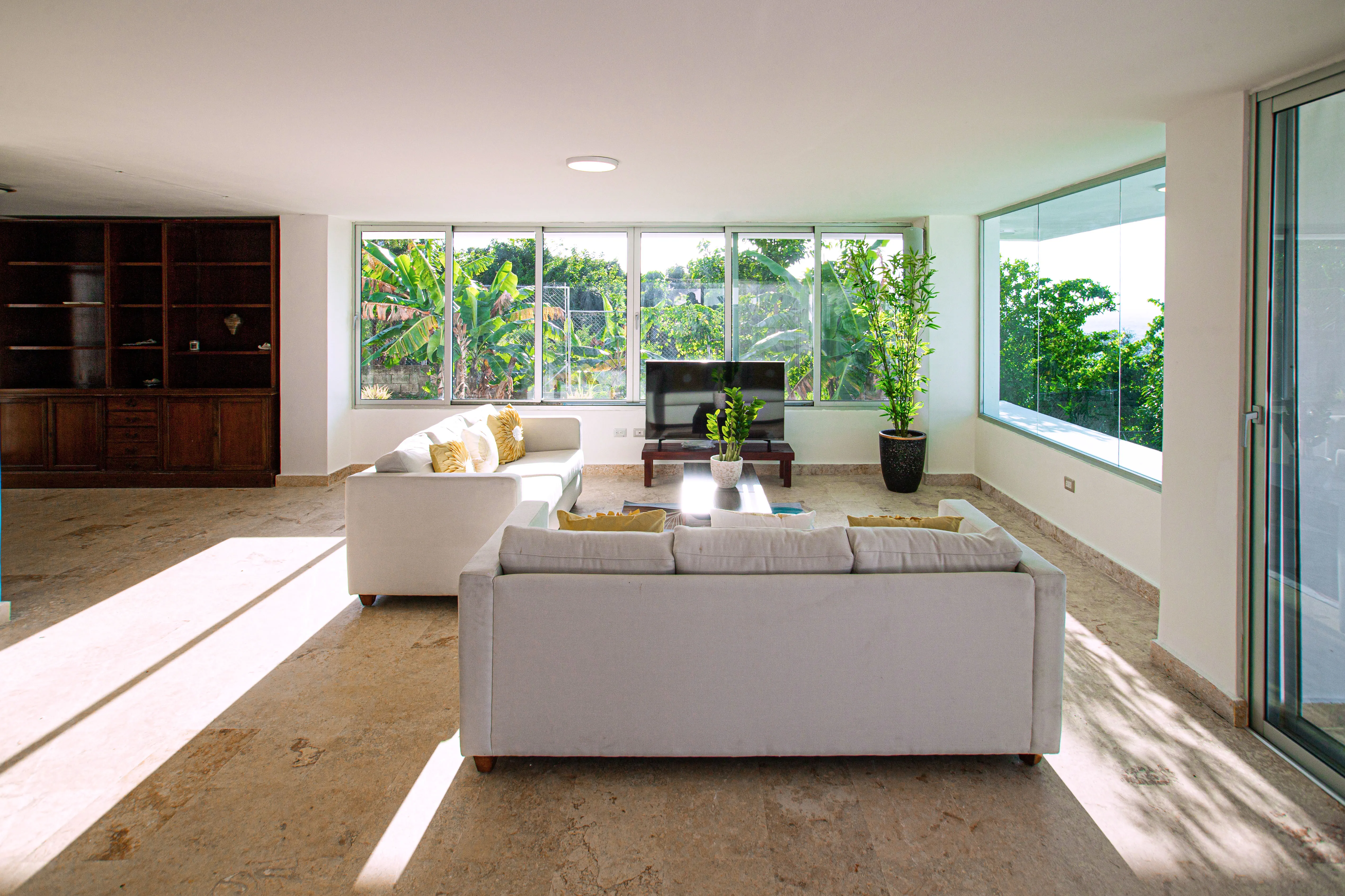 Lower living room with travertine floors and garden-view windows